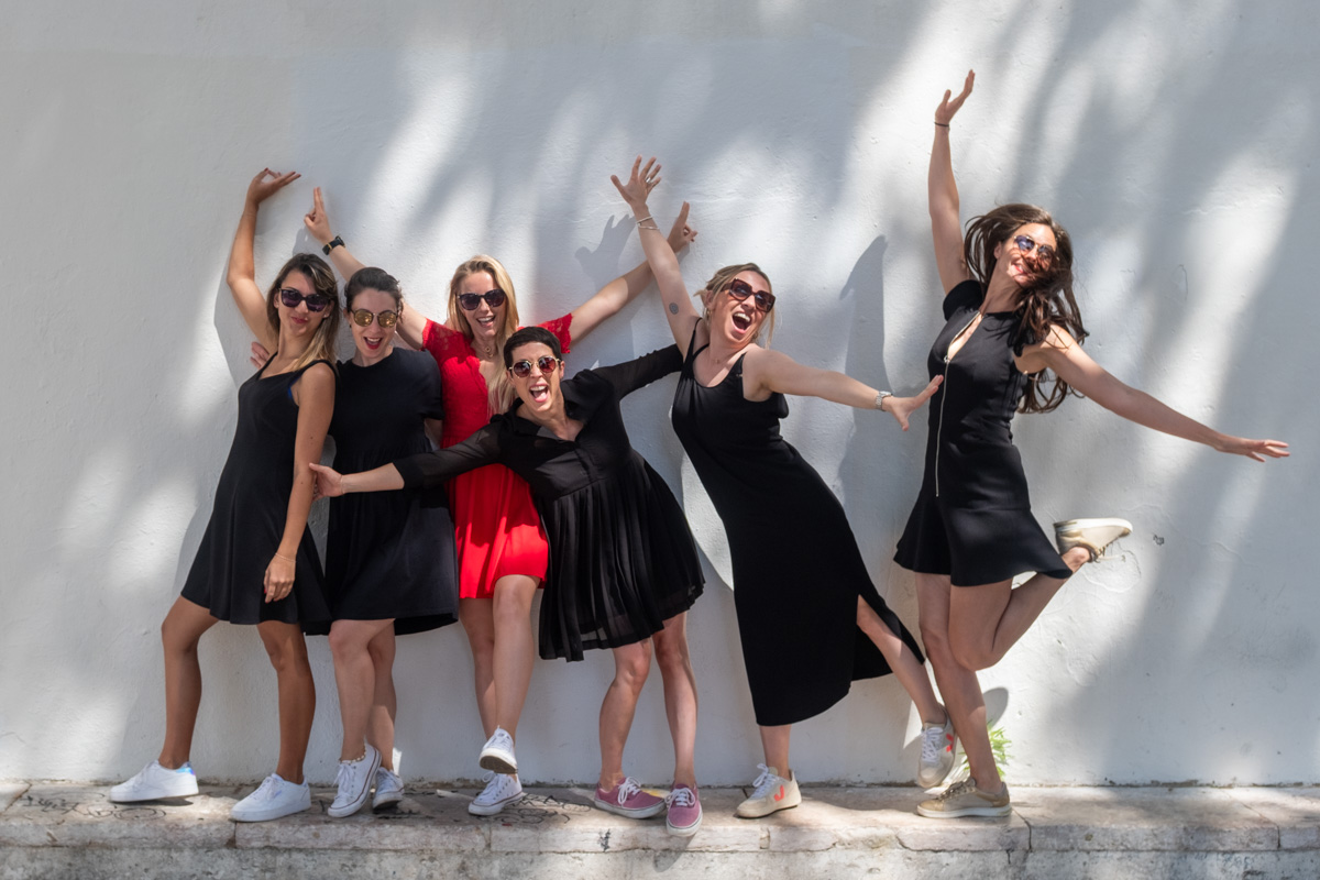 Séance EVJF à Lisbonne, groupe de femmes en robes noires posant devant un mur à Alfama