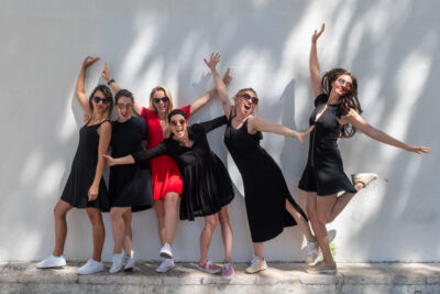 Sessão de despedida de solteira em Lisboa, grupo de mulheres de vestido preto junto a uma parede em Alfama
