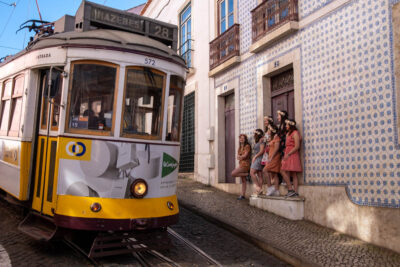Bachelorette photoshoot in Lisbon, group of women in flower crowns in front of tram 28