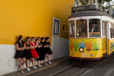 Séance EVJF à Lisbonne, groupe de femmes devant un mur jaune et le tram 28